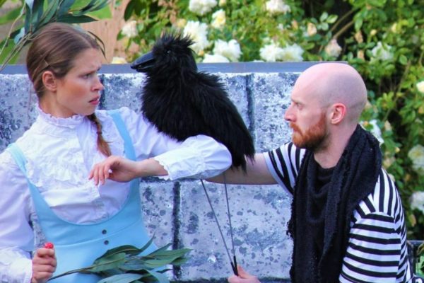 Alice and another actor in the garden with a bird