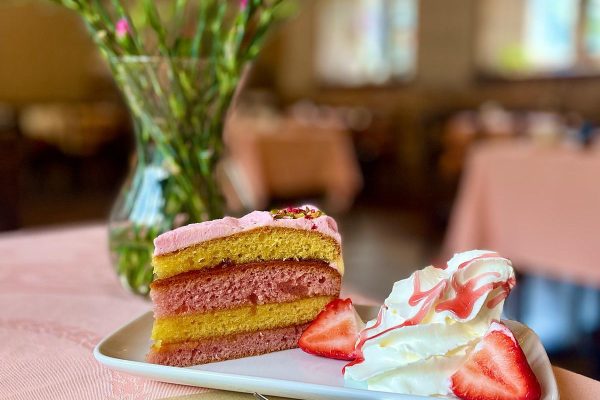 A slice of homemade sponge cake served at the Hoghton Tower Tearoom in Lancashire, topped with fresh cream and strawberries.